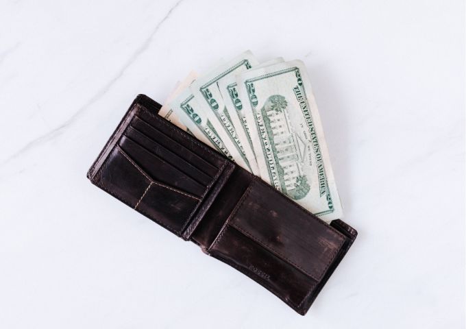 黒い財布からドル札がはみ出している