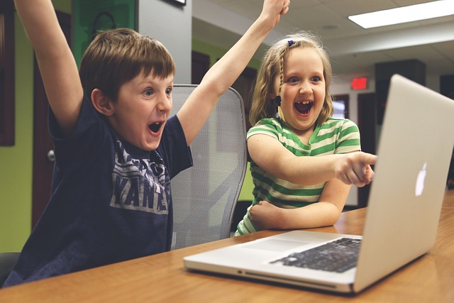 パソコンをみて喜ぶ子供2人